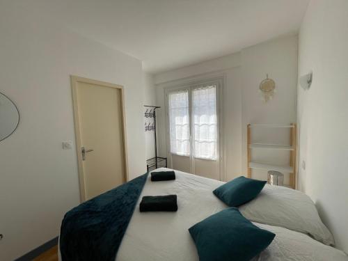 1 dormitorio con 1 cama grande con almohadas verdes en ATLANTIS en Saint-Nazaire