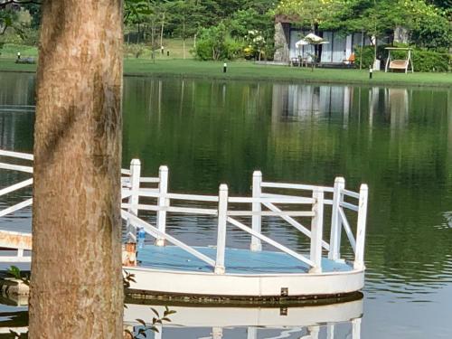 a white boat sitting in the middle of a lake at Đại Lải Resort - Lake view villa in Phúc Yên