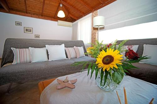 a living room with a couch and a vase with a sunflower at A View from the Attic Window. Kyparissia, Messinia in Kyparissia