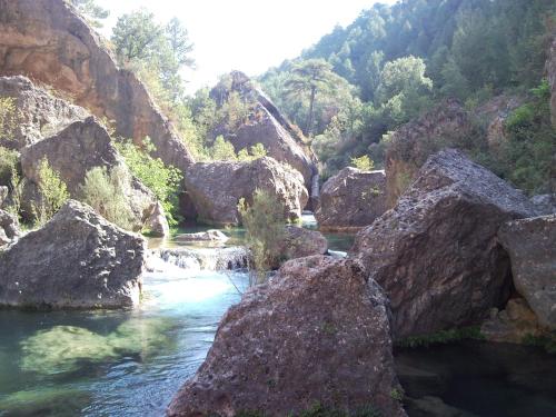 a river with rocks in the middle of a mountain at Ciudad Encantada Tio Daniel in Valdecabras