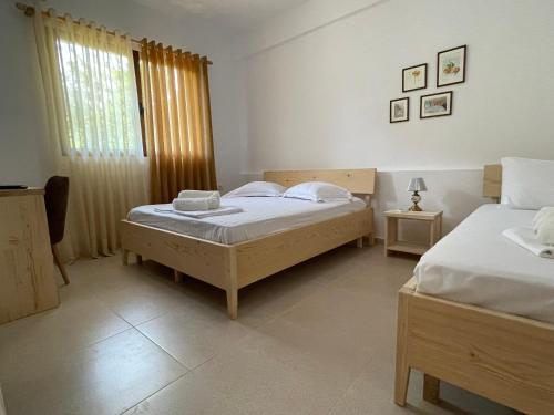 a bedroom with two beds and a window at Xho's Forest Guest House in Berat