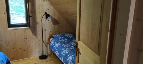 a small room with a bed in a wooden cabin at Planinska hišica pod macesni - Bohinj in Srednja Vas v Bohinju