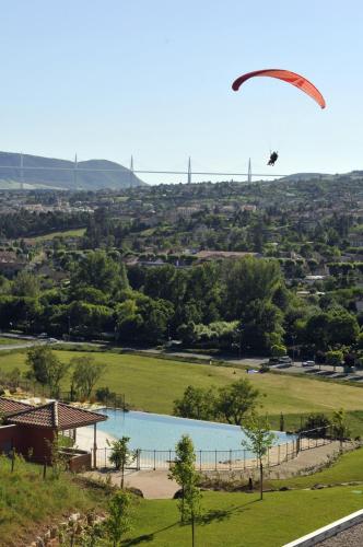 a paraglider is flying over a lake at Domaine Saint Estève in Millau