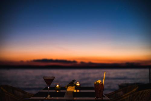 a table with drinks on it with a view of the water at Tópart Hotel in Balatonvilágos