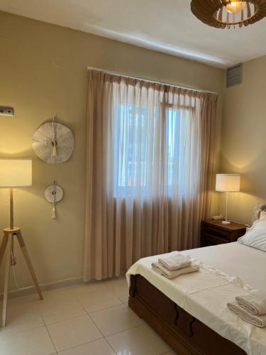 a bedroom with a bed and a window with curtains at la PADINI CASA sul mare in Neoi Epivates