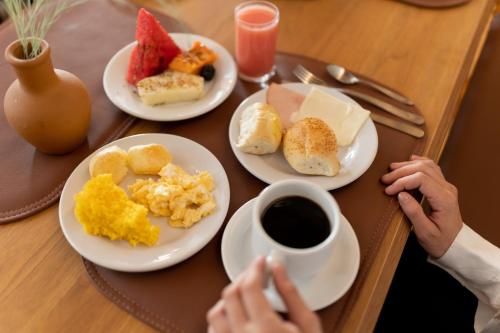 una mesa con platos de comida y una taza de café en Pauli Boutique Hotel, en Fortaleza
