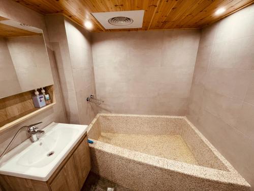 a bathroom with a tub and a sink at Zhiben Wu Jiari in Wenquan
