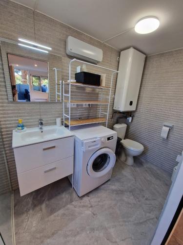une salle de bain avec une machine à laver et un lavabo dans l'établissement Le Navigateur - Canetoise refaite à neuf, à Canet