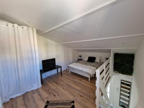 - une chambre avec un lit et une télévision dans l'établissement Le Navigateur - Canetoise refaite à neuf, à Canet