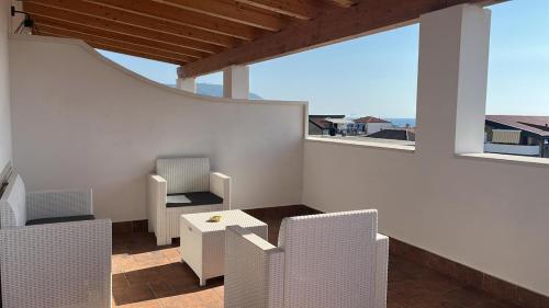a room with chairs and a table and windows at KARIS KAIROS in Santa Maria di Castellabate