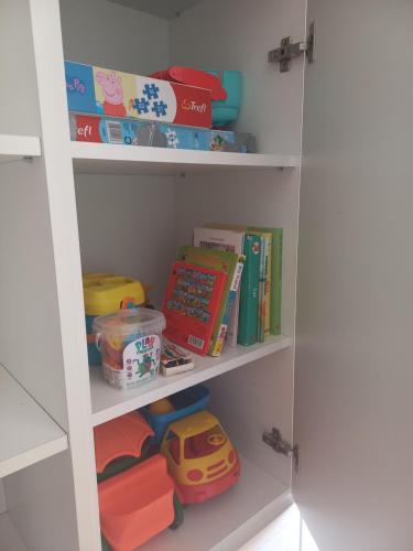 a childs closet with toys and books on shelves at ŁADNE MIESZKANIE W PRZYJAZNEJ OKOLICY - NICE APARTMENT IN a FRIENDLY NEIGHBORHOOD in Suwałki