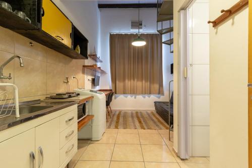 a kitchen with white cabinets and a sink at BH Studios Hotel Brás in Sao Paulo