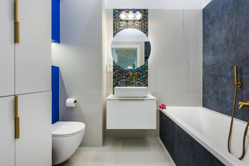 ein Badezimmer mit einer Badewanne, einem WC und einem Waschbecken in der Unterkunft Plac Unii Aquamarine Premium - free parking in Gdynia