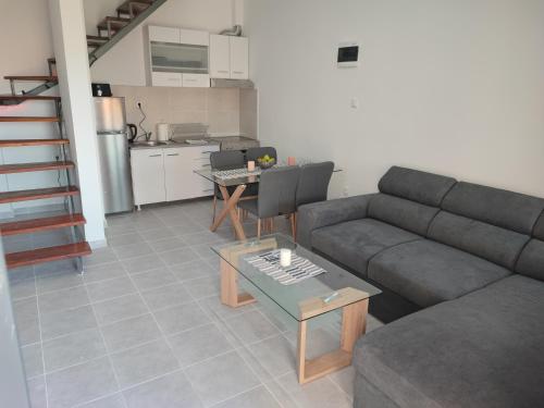sala de estar con sofá, mesa y cocina en Eleven And A Half apartment en Nea Fokea