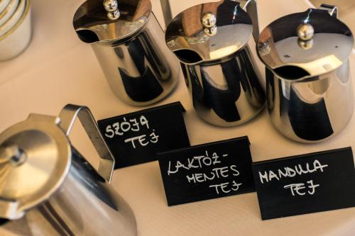 a table with two tea pots and signs on it at Tópart Hotel in Balatonvilágos