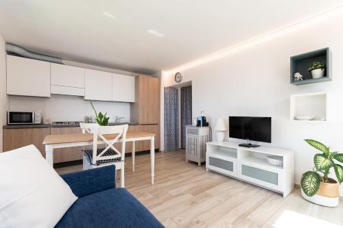 un soggiorno con divano blu e una cucina di La Roccia Fiorita Appartamento con giardino e Jacuzzi a Varazze