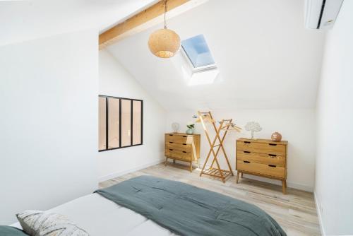 ein weißes Schlafzimmer mit einem Bett und einer Kommode in der Unterkunft CASA MAMALOSA & SPA in Andernos-les-Bains