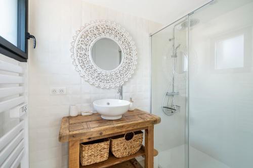 ein Bad mit einem Waschbecken und einem Spiegel in der Unterkunft CASA MAMALOSA & SPA in Andernos-les-Bains