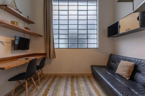 a living room with a couch and a desk at BH Studios Hotel Brás in Sao Paulo