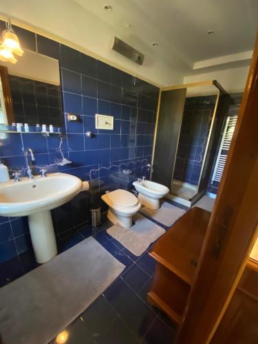 uma casa de banho azul com um lavatório e um WC em VILLA FIESCHI em Cogorno