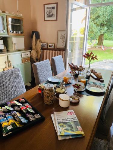 a wooden table with food on it in a kitchen at Les Hirondelles de la villa des roses in Pontmain