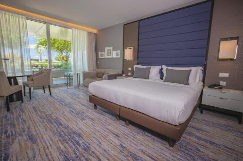 a bedroom with a large bed and a living room at InterContinental Cascais-Estoril by IHG in Estoril