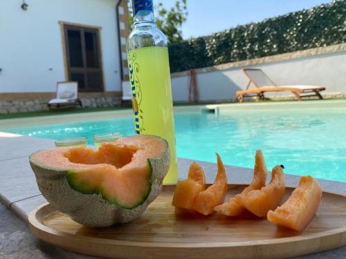 a piece of fruit on a cutting board next to a bottle at Country house relais Nonna Rosa Rosolini (SR) in Siracusa