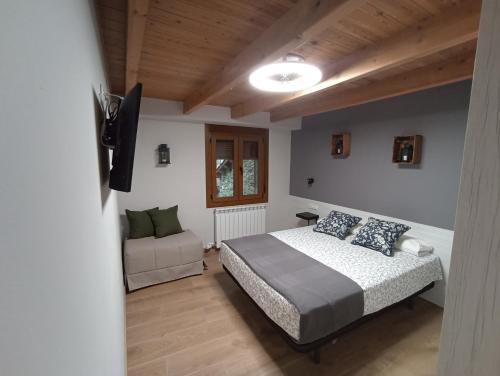 ein Schlafzimmer mit einem Bett und einem Stuhl darin in der Unterkunft Parada de Txambonet 3 in Vilaller