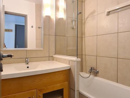La salle de bains est pourvue d'un lavabo, d'un miroir et d'une baignoire. dans l'établissement Appartement Flaine, 2 pièces, 5 personnes - FR-1-425-165, à Flaine
