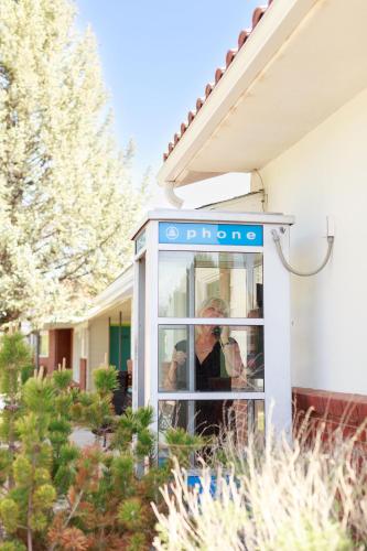 a woman standing in a phone booth in front of a house at Retro Inn at Mesa Verde in Cortez