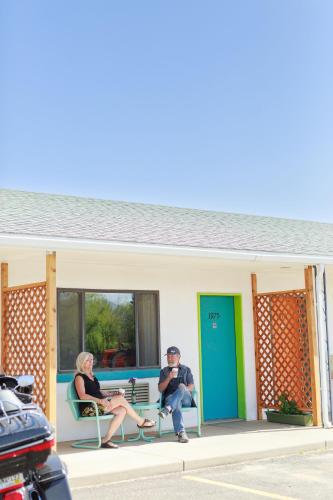 three people sitting on chairs in front of a house at Retro Inn at Mesa Verde in Cortez