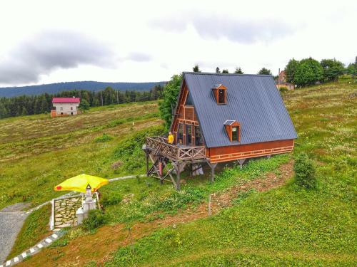 une petite maison sur une colline avec un parasol dans l'établissement Zifinbungalov, à Akcaabat
