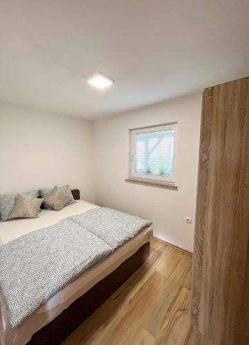 a bedroom with a bed and a window at Tomajna Vineyard Stay in Podlehnik