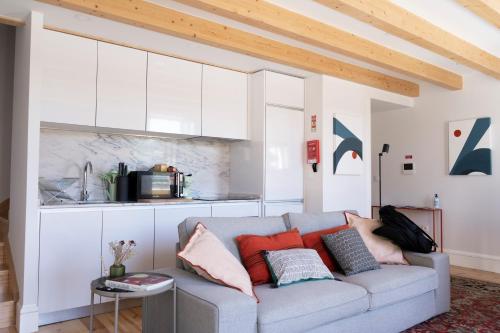 a living room with a couch and a kitchen at Casa Girasol River View in Porto