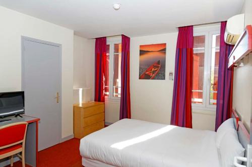 sypialnia z białym łóżkiem i czerwonymi zasłonami w obiekcie Hôtel du Vigan w mieście Albi