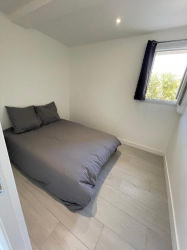 un lit dans une chambre avec une fenêtre dans l'établissement appartement bas de villa avec piscine privée partagée proche bord de mer, à Cagnes-sur-Mer