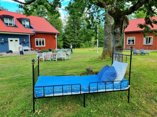 a bed with blue sheets and pillows in a yard at Bolmen Bed - Vandrarhem in Ljungby