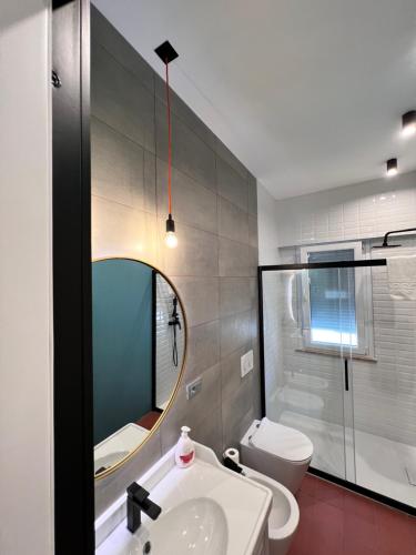 La salle de bains est pourvue d'un lavabo, de toilettes et d'un miroir. dans l'établissement Appartamento di design a 30 metri dal mare, à Alba Adriatica