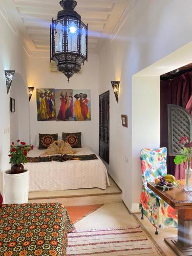 sypialnia z łóżkiem i żyrandolem w obiekcie Dar Soukaina w Marakeszu