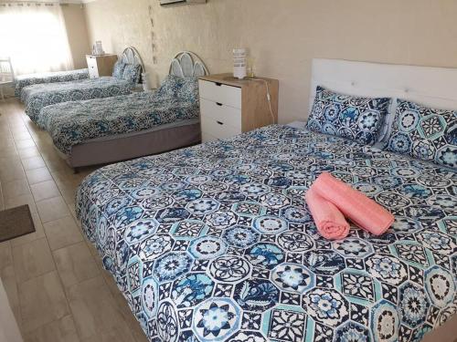 1 Schlafzimmer mit 3 Betten und einem roten Kissen auf dem Bett in der Unterkunft Beach House with DSTV & WIFI & basic housekeeping in Knysna