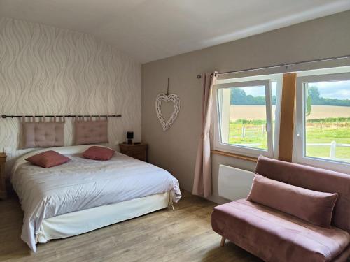 a bedroom with a bed and a window and a couch at Gîte équestre. Ferme des Essarts in Maucomble