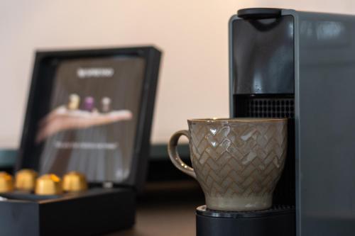 アダマスにあるOlive Studiosの電子レンジの横のテーブルに座ったコーヒーカップ