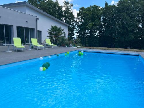 a blue swimming pool with balls in the water at Domaine Georges V in Saint-Junien