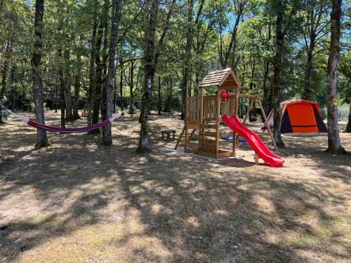 a playground with a slide and a swing set at Domaine Georges V in Saint-Junien
