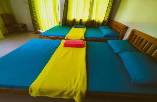 a bedroom with two beds with blue and yellow covers at Condo Stay at Paranaque with Unlimited WIFI v3 in Manila