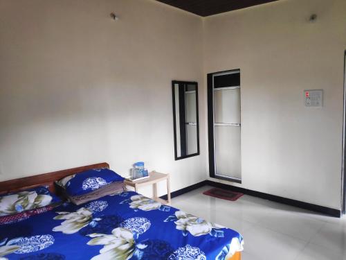 a bedroom with a blue and white bed and a mirror at Ashish Baug Cottage in Alibaug