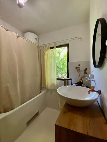 a bathroom with a sink and a tub and a mirror at Casa Madre Kravice Waterfalls in Ljubuški