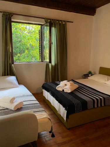 two beds in a room with a window at Casa Madre Kravice Waterfalls in Ljubuški