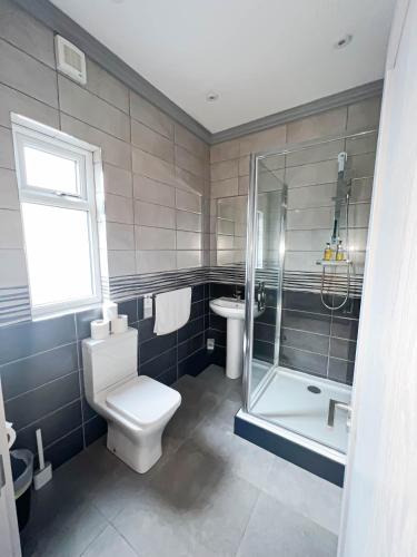 a bathroom with a toilet and a shower and a sink at Central Station Hotel Liverpool in Liverpool