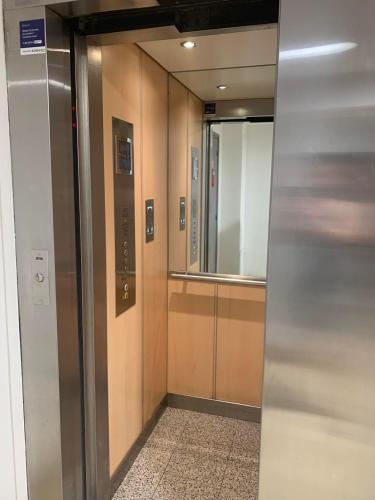 a elevator in a building with a mirror on the wall at BEST CENTRAL Chambres Privées - Seine & Louvre in the Connected Heart of Paris in Paris